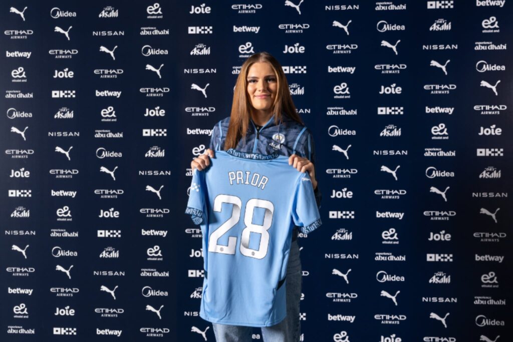 Gracie Prior holds up number 28 shirt for Man City